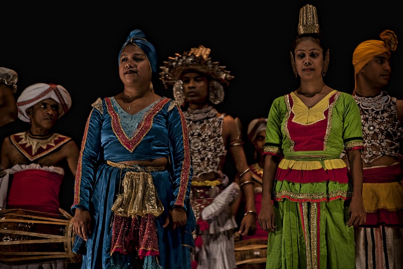 A Kandyan dancer in a silver headdress and red costume