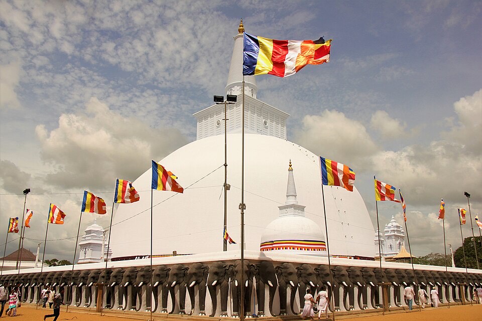 The white Ruwanwelisaya stupa in Anuradhapura with Buddhist flags